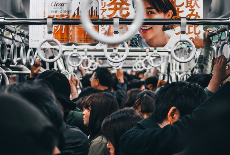 View down the inside of a crowded Tokyo commuter train carriage